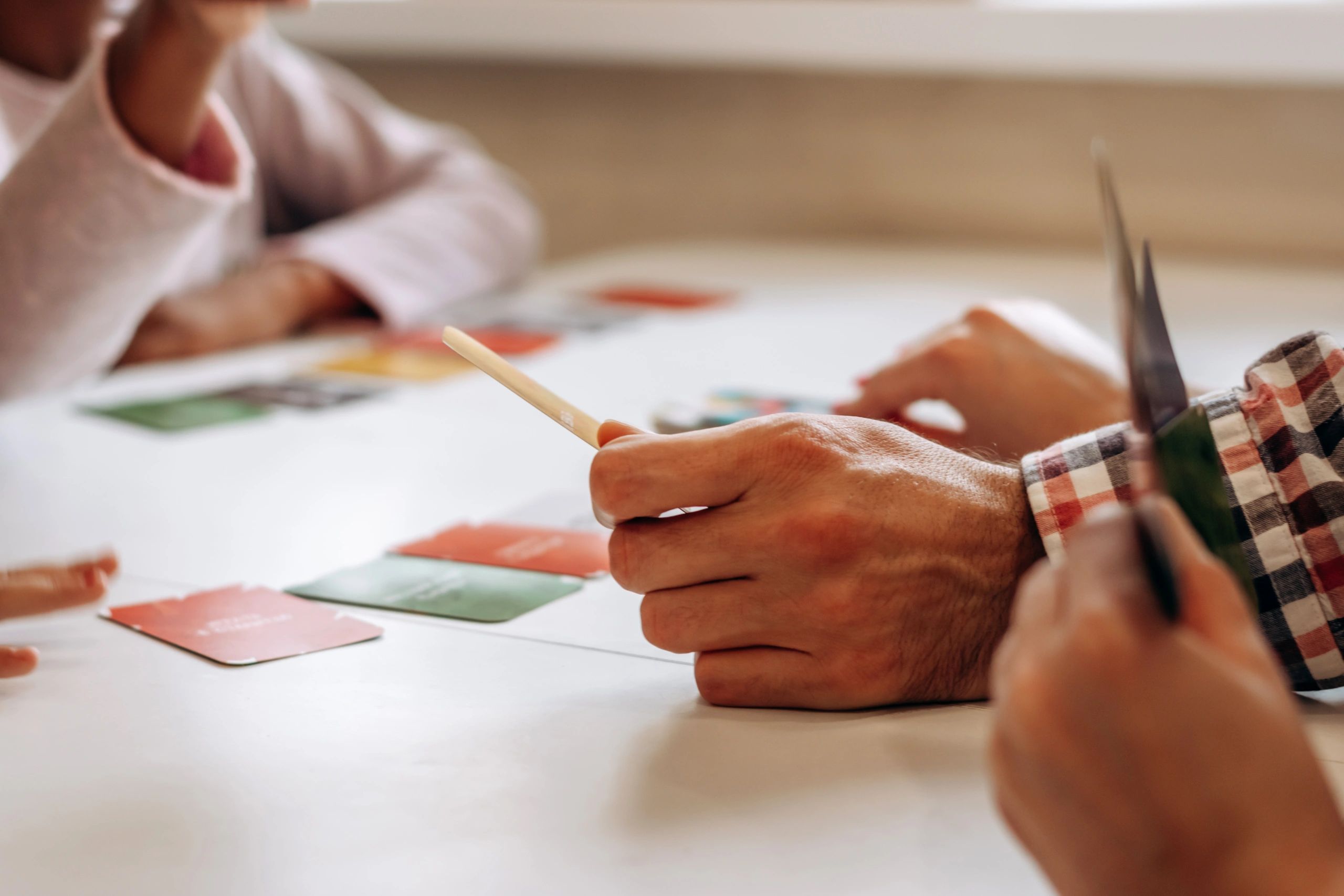 Hands around a table during a game night, representing the player community