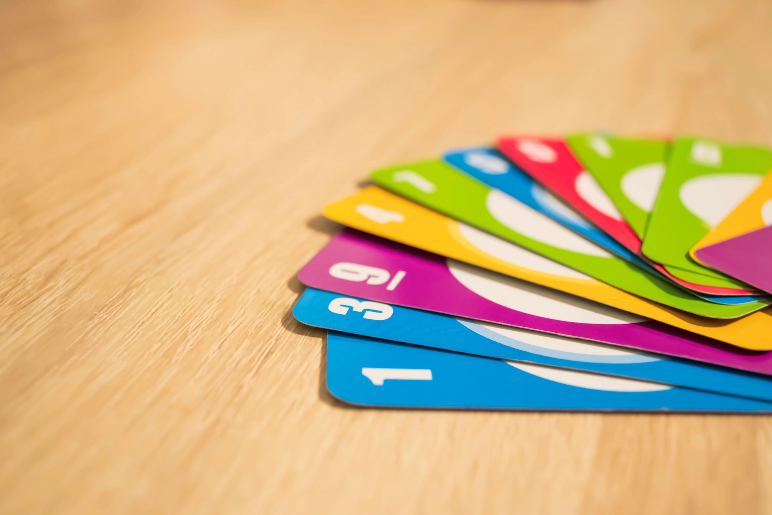 Colorful trading card game cards fanned out on a wooden table