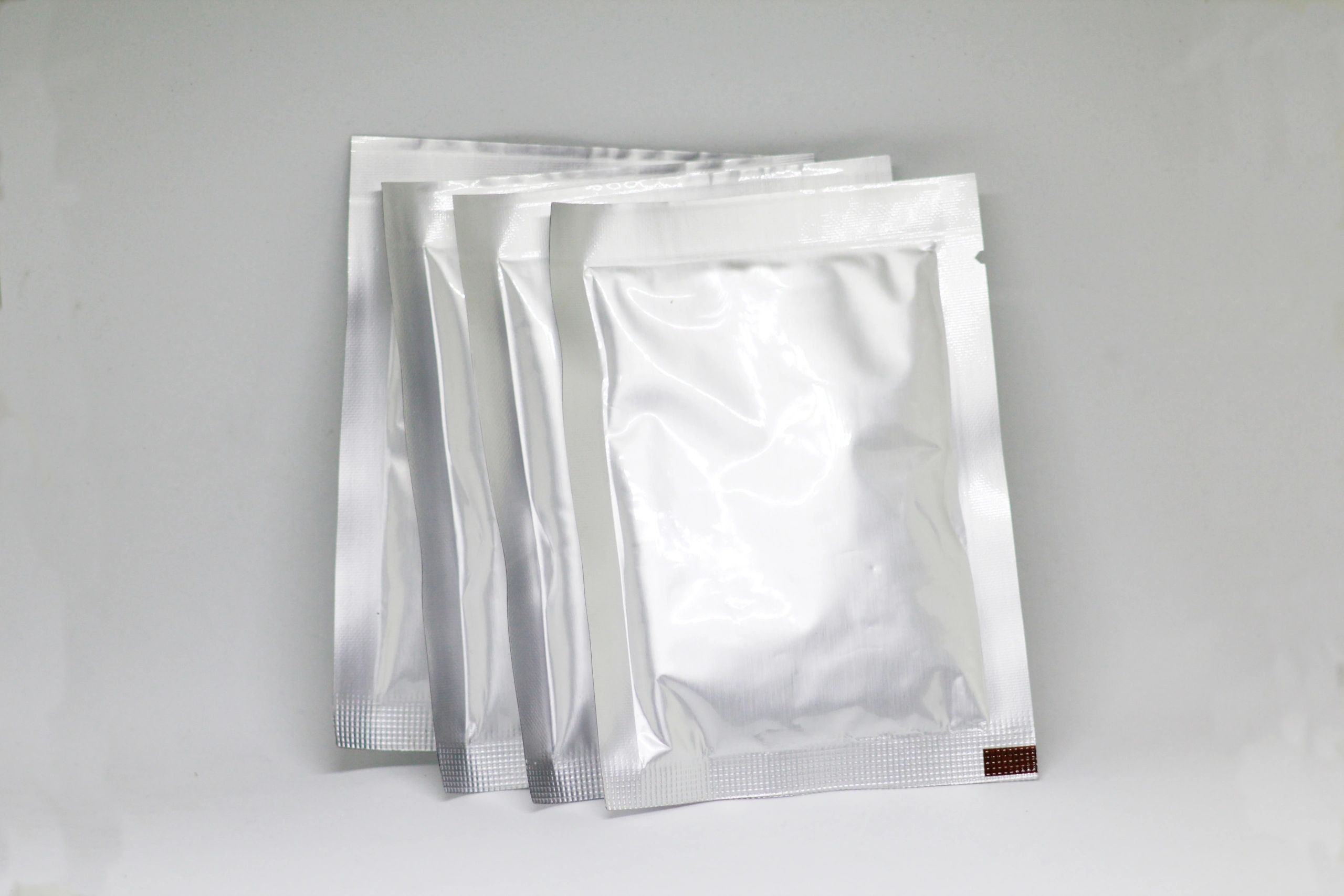 Sealed foil packets on a clean background representing sealed products