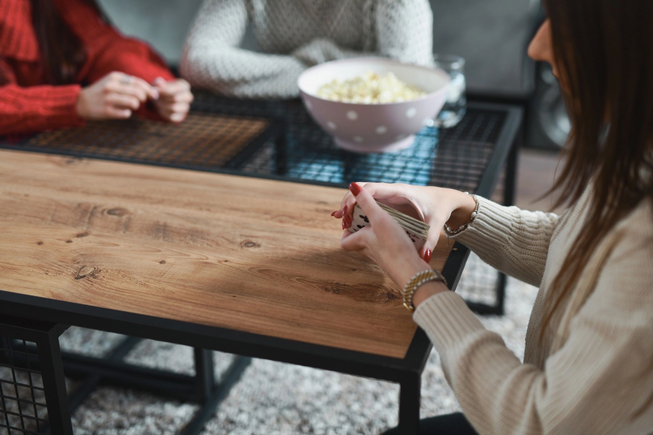 People holding and playing with cards at a table